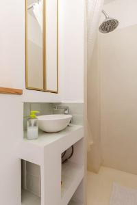 a white bathroom with a sink and a mirror at Ma Petite Versailles in Versailles