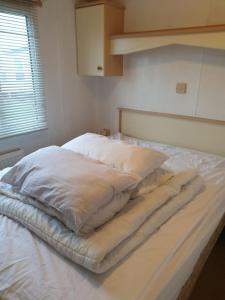 a large white bed in a room with a window at Great Deals at The Grange, Ingoldmells in Skegness
