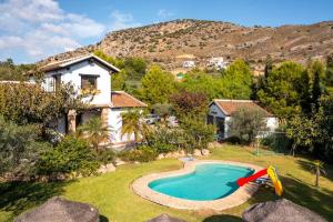 a house with a swimming pool in a yard at Maravillosa Casa Rural Alegría in Málaga