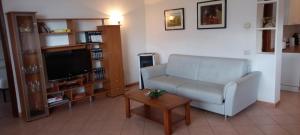 a living room with a couch and a tv and a table at casa camelie in Pino Lago Maggiore