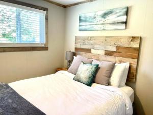 una camera con letto bianco e testiera in legno di Arena del Mar a Grayland