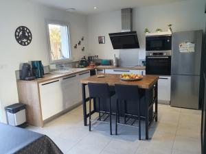 een keuken met een tafel met daarop een schaal fruit bij LA PETITE SALAMANDRE des Conches in Longeville-sur-Mer