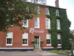 a red brick building with ivy on it at The Riverside House Hotel in Mildenhall