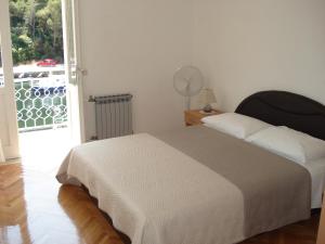 a bedroom with a bed and a door to a balcony at Apartments Luka in Korčula