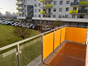 a balcony with a yellow railing and a parking lot at Apartament Słowackiego Września in Września
