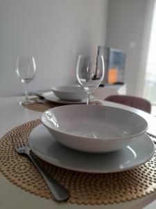 a table with a plate and two wine glasses on it at Apartament Słowackiego Września in Września