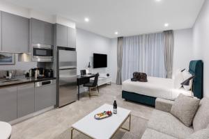 a hotel room with a king bed and a kitchen at Meriton Suites Sussex Street, Sydney in Sydney
