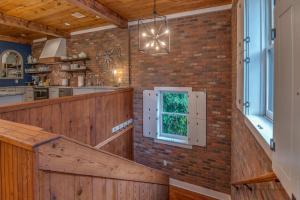 a kitchen with a brick wall and a window at The Loft on Trade Street in Tryon