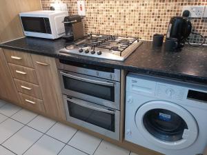 a kitchen with a stove top oven next to a microwave at Private Luxury Room Southampton in Southampton