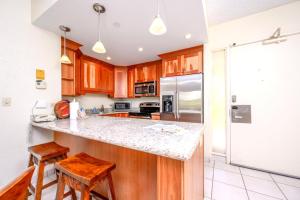 a kitchen with wooden cabinets and a counter top at K B M Resorts- KS-155 Spacious 2Bd at the famous ocean front Kaanapali Shores Resort in Kaanapali