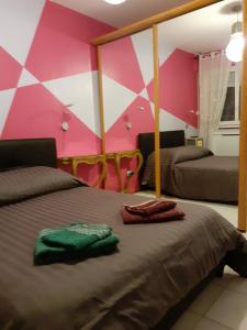 コルマールにあるAppart' Charmant Piccola Veneziaのピンクと白の壁のベッドルーム1室
