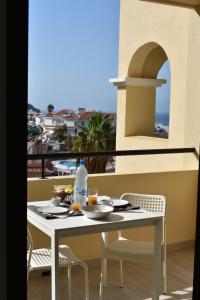 Una mesa y sillas en un balcón con vista al mar. en Castle Margherita's Apartments, en Los Cristianos