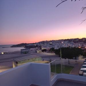 een uitzicht op een parkeerplaats bij zonsondergang met een stad bij Sunset View Apartment - 22 in Albufeira