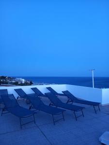 een groep stoelen en tafels op een dak bij Sunset View Apartment - 22 in Albufeira +17 foto's