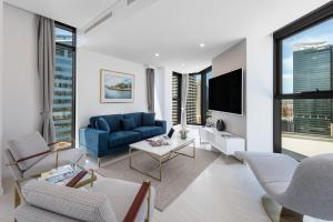 a living room filled with furniture and a window at Meriton Suites Sussex Street, Sydney in Sydney