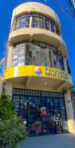 a building with a yellow sign on top of it at Pousada Mucuripe in Fortaleza