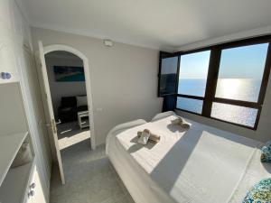 a bedroom with a bed with a view of the ocean at Doñana12 by SunHousesCanarias in Patalavaca