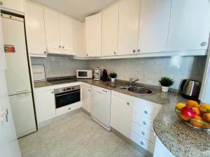 a kitchen with white cabinets and a bowl of fruit on the counter at Doñana12 by SunHousesCanarias in Patalavaca
