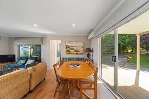 a living room with a table and a couch at Lakeside Vistas Magic - Rainbow Point Home in Taupo