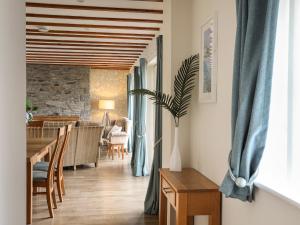 a living room with a table and a dining room at Tyn Towyn - Ty Coch in Trearddur