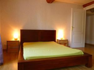 a bedroom with a bed with two lights on two tables at Maison ancienne entièrement rénovée pour 5 personnes in Bény-sur-Mer