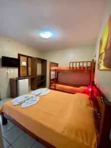 un dormitorio con una cama y dos literas en Pousada Mucuripe, en Fortaleza
