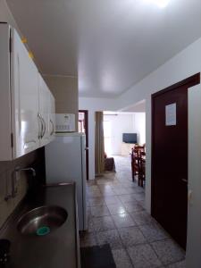 uma cozinha com pia e uma sala de estar em Ótimo apartamento na Prainha Torres/RS em Torres mais 13 fotografias