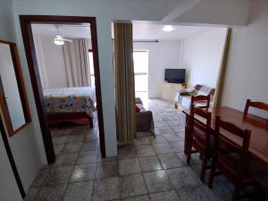 uma sala com um quarto e uma sala de estar com uma mesa em Ótimo apartamento na Prainha Torres/RS em Torres