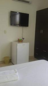 a room with a refrigerator and a tv on the wall at Hotel Canacabare Plaza in Yopal