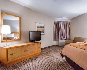 a hotel room with a bed and a television at Rodeway Inn Saint John in Saint John
