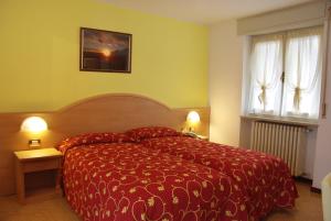 a bedroom with a red bed and a window at Hotel Residence Panoramica in Brenzone sul Garda