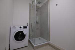 La salle de bains est pourvue d'un lave-linge et d'un lave-linge. dans l'établissement Port 3 - Exklusives City Apartment, à Bremerhaven