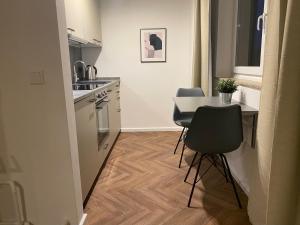 une petite cuisine avec une table et des chaises. dans l'établissement Port 3 - Exklusives City Apartment, à Bremerhaven