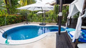 una piscina con sombrilla junto a una piscina en Villas Aqua Los Cabos, en Monterrico