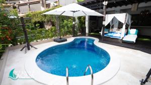 a swimming pool with an umbrella and a chair at Villas Aqua Los Cabos in Monterrico