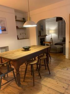 een eetkamer met een houten tafel en stoelen bij White Heather Terrace in Bovey Tracey