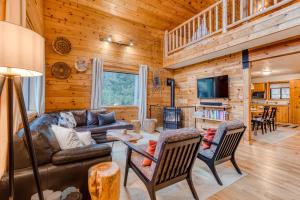 Blue Pine Chalet في غوفيرمنت كامب: غرفة معيشة مع أريكة وكراسي في كابينة