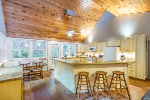 uma cozinha em plano aberto com tectos em madeira e bancos de bar em Mountain Top Tranquility em Sylva