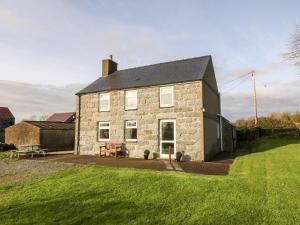 an old stone house with a picnic table in front of it at Prys Mawr in Chwilog