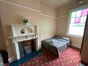 a bedroom with a fireplace and a bed and a window at Royal Hotel Motel Scone in Scone +40 photos