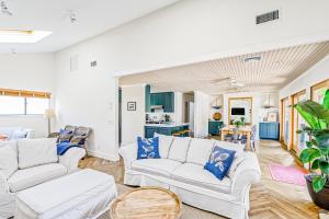 a living room with white furniture and blue accents at Paradiso in Ocean Beach