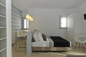 ナウサにあるRomantica Suitesのベッドルーム1室(ベッド1台、テーブル、椅子付)