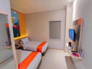 ein Hotelzimmer mit 2 Betten und einem TV in der Unterkunft Front One Budget Abepura in Abepura