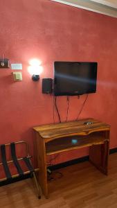 a television on a wall with a wooden table at Highlander Motel in Williams