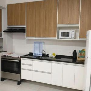 a kitchen with white cabinets and a laptop on the counter at Temporada Ubatuba in Ubatuba