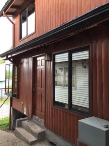 a wooden house with a door and a window at Apartamentos Patagonia Dove in Coihaique