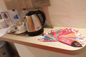 Abepura的住宿－Front One Budget Abepura，咖啡壶,放在柜台上,配有咖啡壶