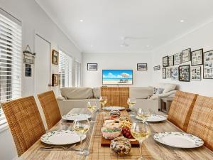 a dining room with a table with wine glasses at Windspray in Culburra Beach
