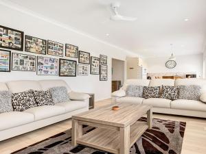 a living room with two white couches and a coffee table at Windspray in Culburra Beach +12 photos
