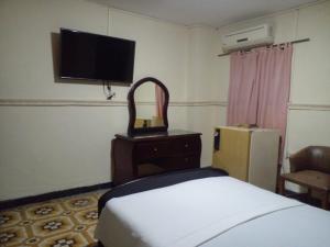 a bedroom with a bed and a flat screen tv at Hotel El Diamante CA in Barranquilla